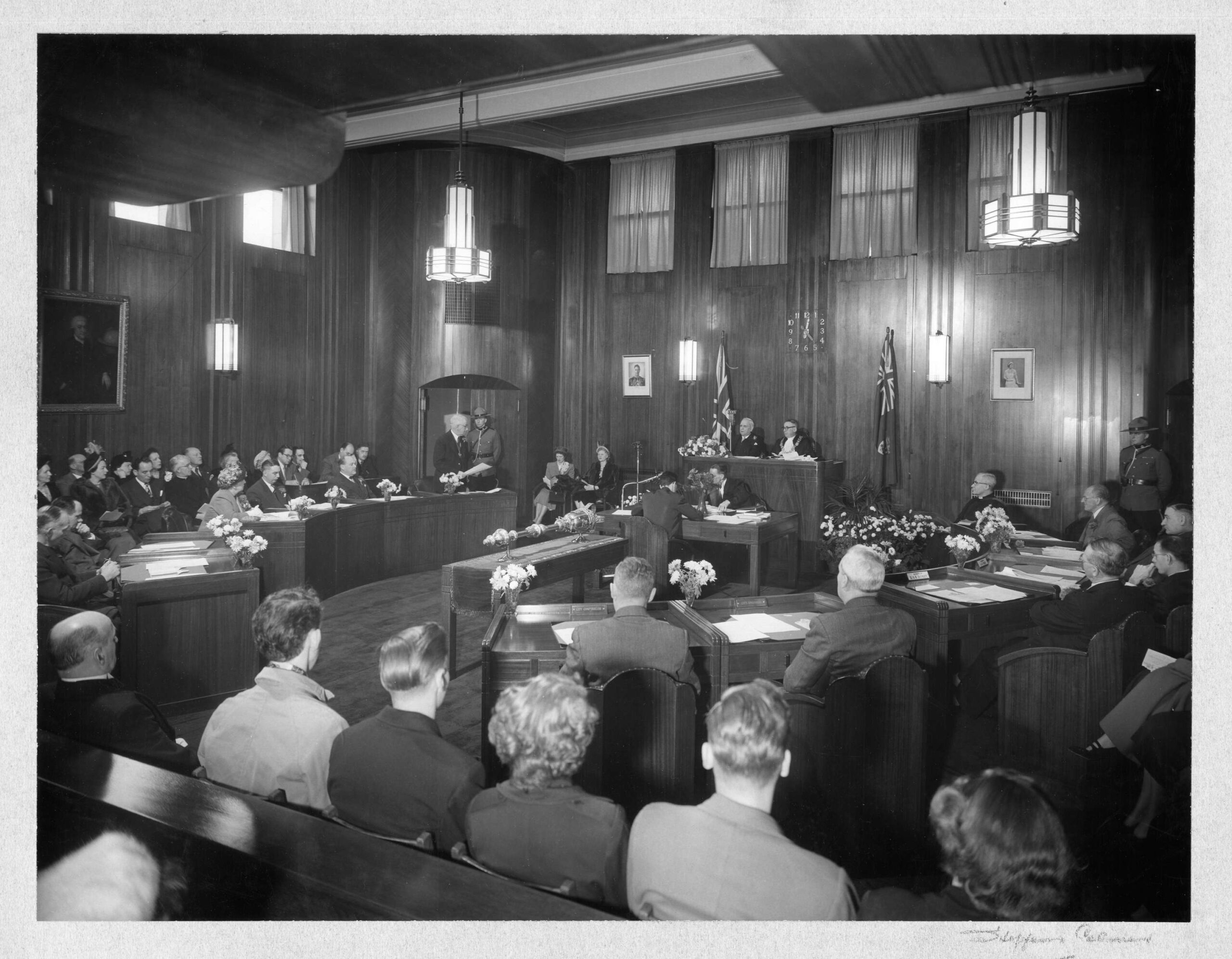 Council chambers during a meeting in progress, 1949. The City Clerk is at the desk in front of the Mayor, taking the minutes. Reference code: COV-S62-: CVA 296-350